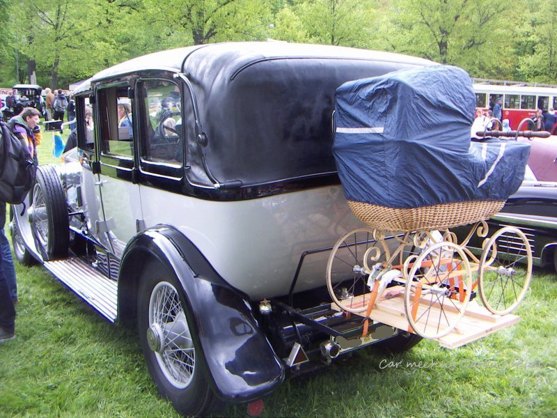 A Rolls Royce with a stroller at the back